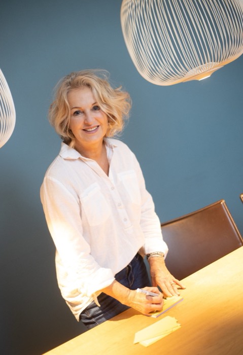 Monika Klis steht an einem Holztisch in ihrem Beratungsraum