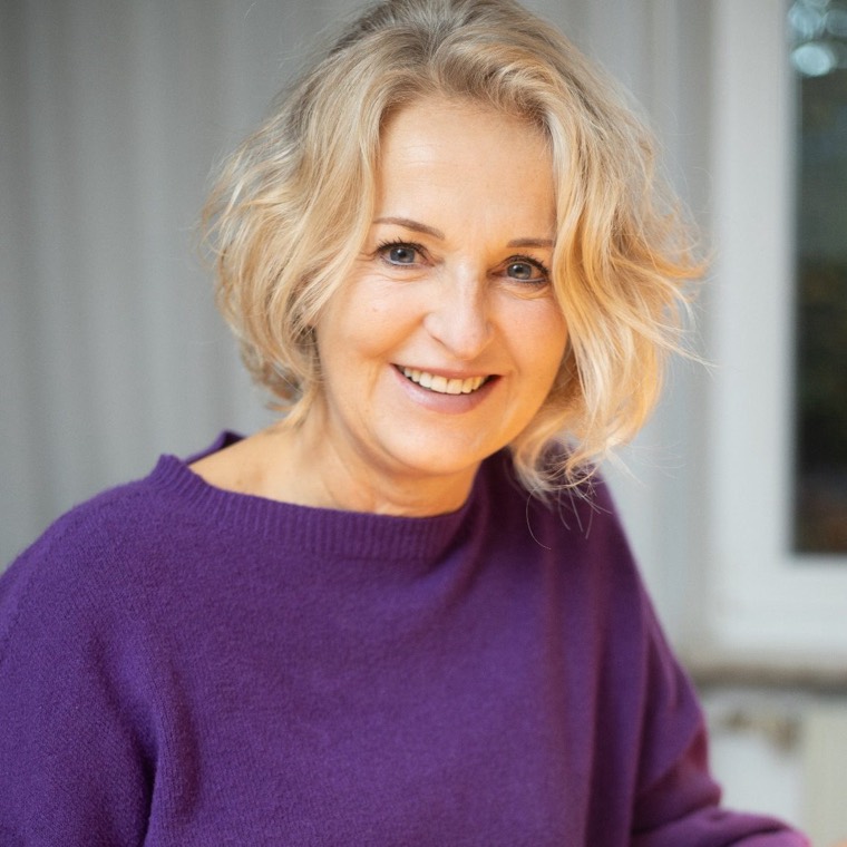 Monika Klis, lächelnd, in einem violetten Pullover